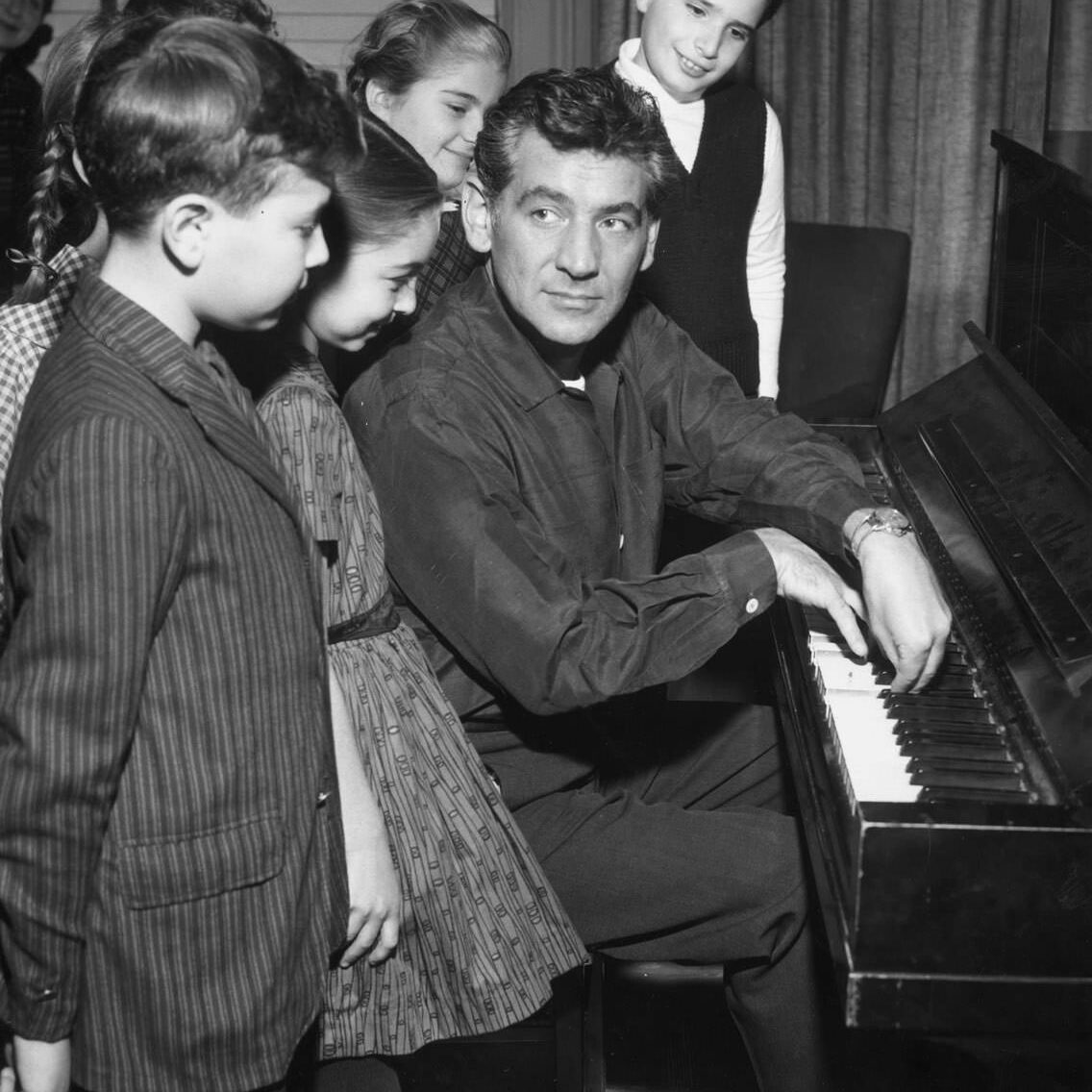 1958:  American composer Leonard Bernstein (1918 - 1990) plays piano for a group of children, New York City.  (Photo by CBS Photo Archive/Getty Images)